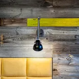 Czarna lampa na szarych deskach ściennych z zielonym akcentem