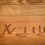 Zbliżenie powierzchni blatu ręcznie rżniętego — ślad dawnej obróbki wyryty w drewnie
