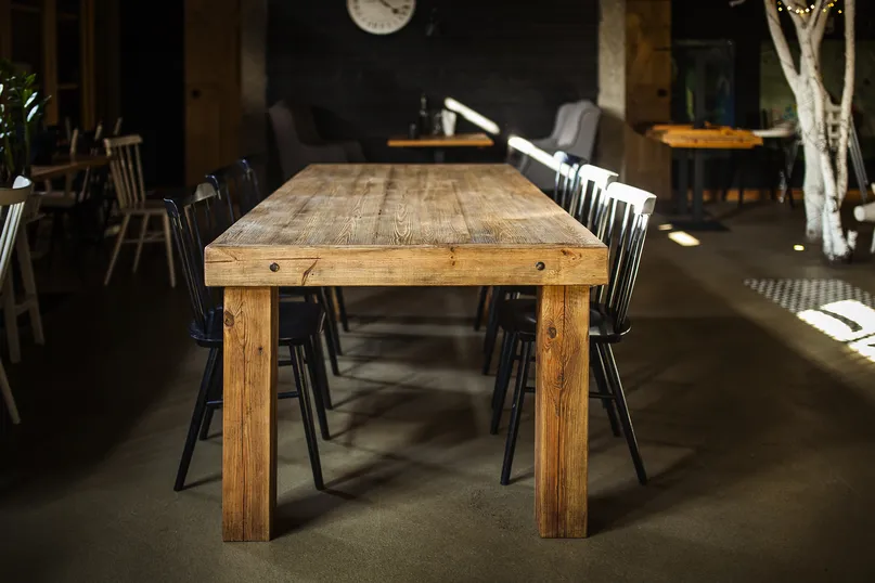 Stół drewniany ze starego drewna ARIZONA w restauracji — ujęcie wzdłuż blatu w kolorze naturalnym