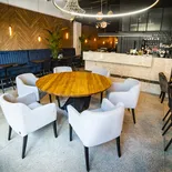Okrągły stół DALLAS z sześcioma fotelami w sali kawiarni z drewnianą boazerią