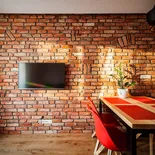 Ściana ceglana z płytek TORUŃSKICH w salonie z telewizorem – styl loft